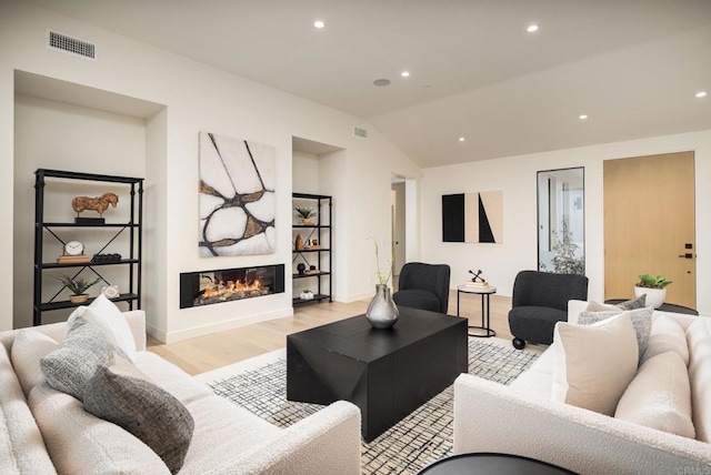 living room with vaulted ceiling and light hardwood / wood-style floors