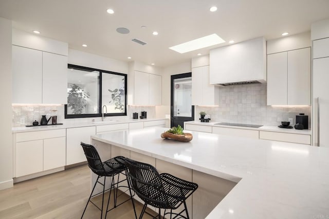 kitchen with black electric stovetop and white cabinets