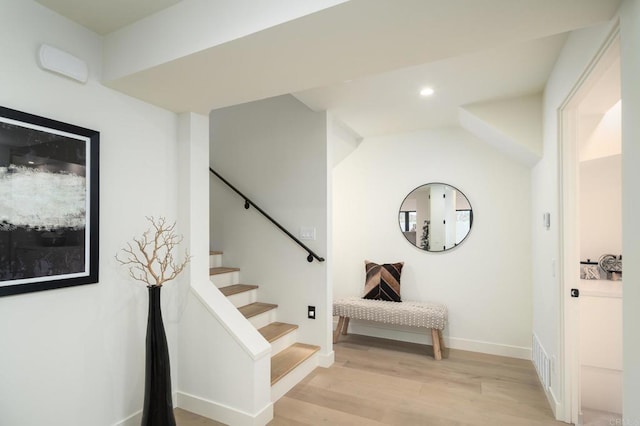 stairs featuring vaulted ceiling and hardwood / wood-style floors