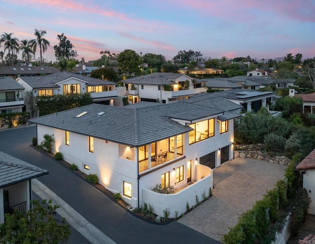 back house at dusk with a garage