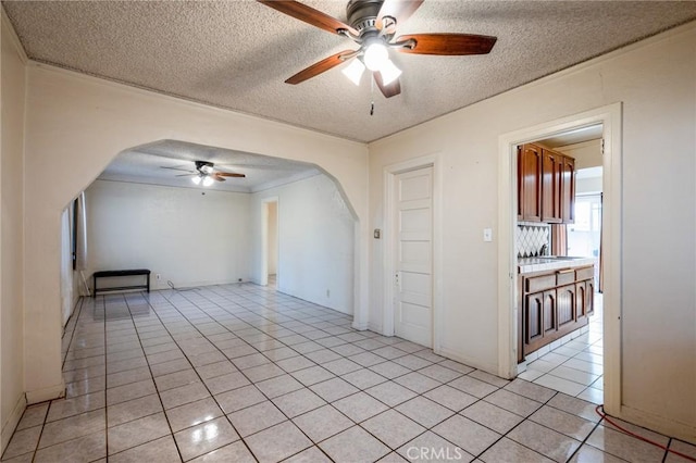 tiled empty room with ceiling fan and a textured ceiling