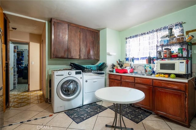 laundry area featuring separate washer and dryer, light tile patterned floors, and sink