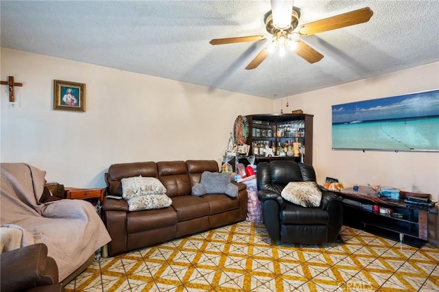 living room featuring ceiling fan and a textured ceiling