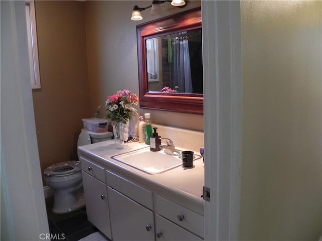 bathroom featuring vanity, tile patterned floors, and toilet