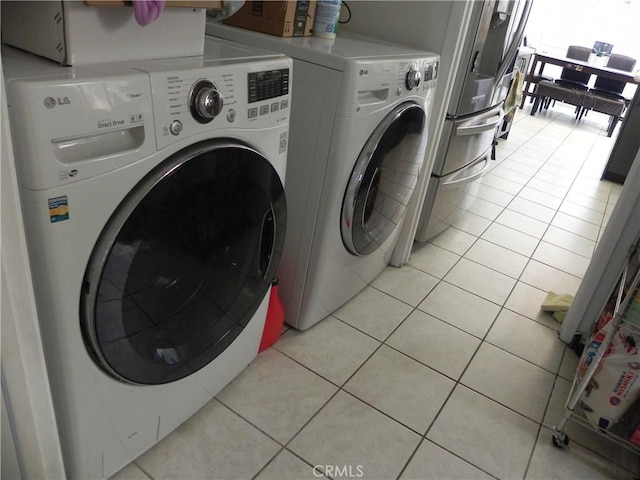 laundry area featuring washer and clothes dryer and light tile patterned flooring