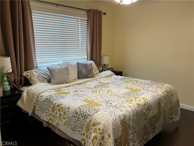 bedroom with dark hardwood / wood-style floors