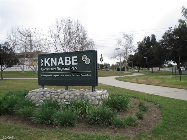 community / neighborhood sign featuring a yard