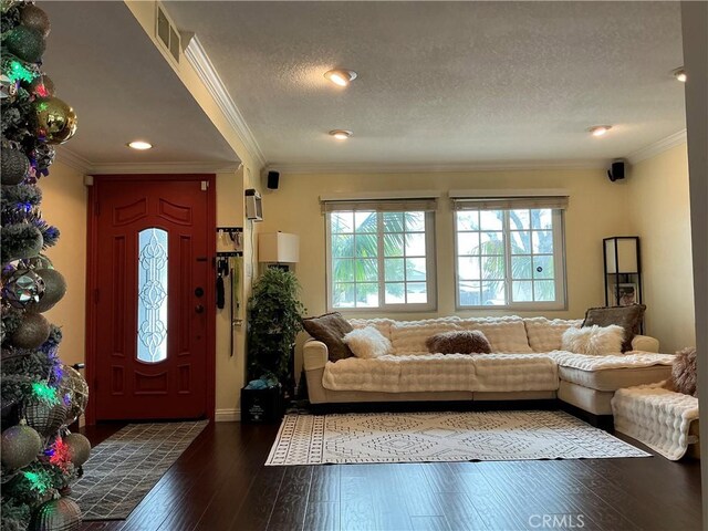 living room featuring hardwood / wood-style floors, ornamental molding, and a textured ceiling