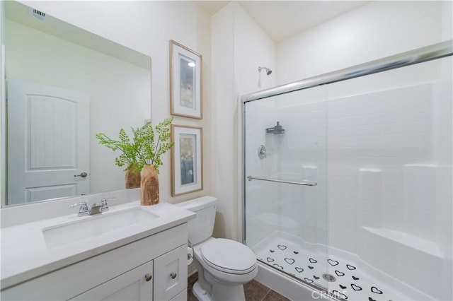 bathroom featuring toilet, tile patterned flooring, an enclosed shower, and vanity