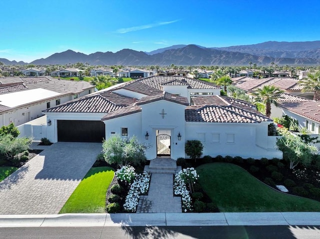 mediterranean / spanish-style home with a garage and a mountain view