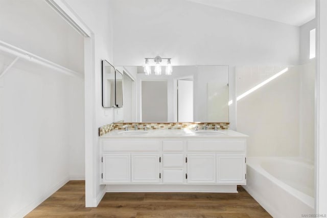 bathroom with a bathtub, wood-type flooring, and vanity