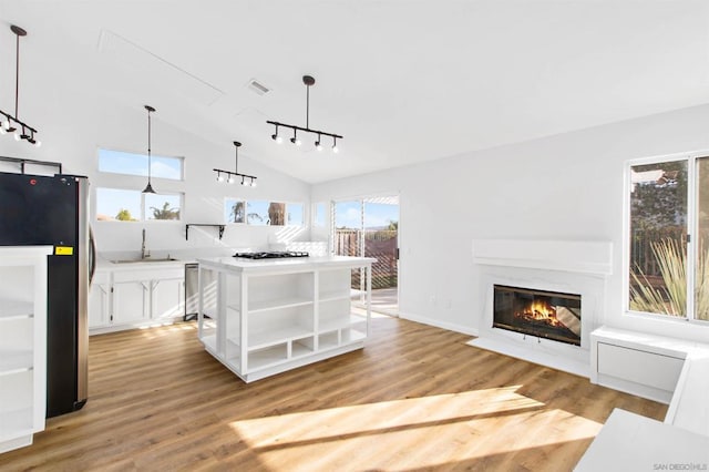 living room with sink, light hardwood / wood-style flooring, and lofted ceiling