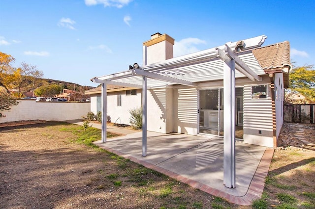 rear view of property featuring a patio area and a pergola