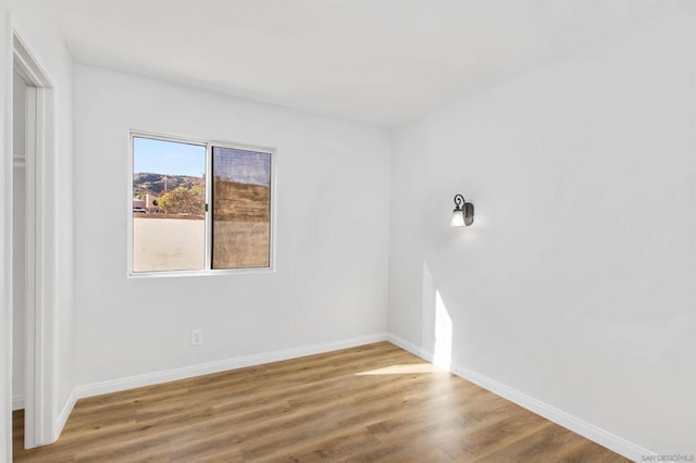 empty room with hardwood / wood-style flooring