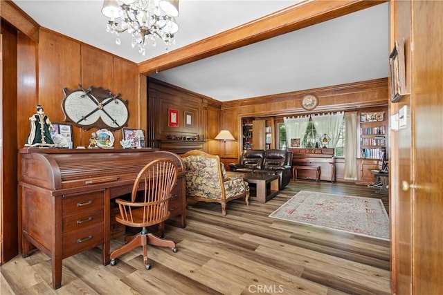 office space with light wood-type flooring, an inviting chandelier, and wooden walls