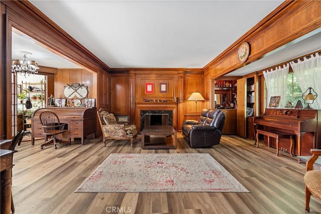 living room with light hardwood / wood-style flooring, wood walls, and a healthy amount of sunlight