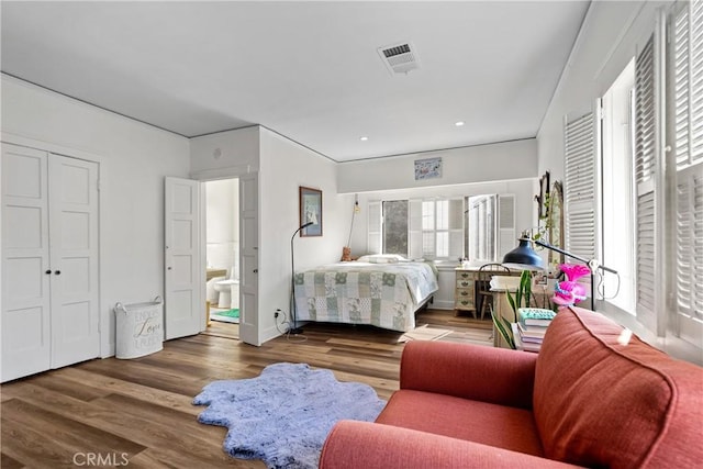 bedroom featuring connected bathroom and hardwood / wood-style flooring