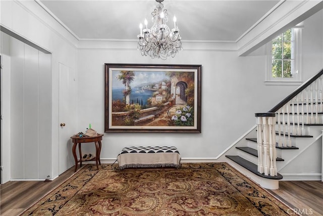 entrance foyer with wood-type flooring, a notable chandelier, and ornamental molding