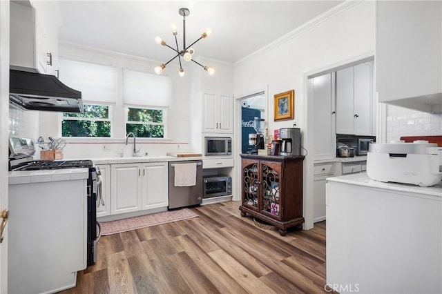 kitchen with extractor fan, stainless steel appliances, backsplash, white cabinets, and sink