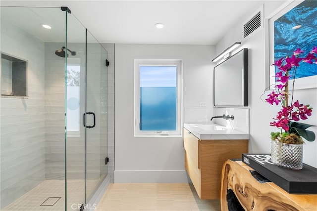 bathroom with tile patterned floors, an enclosed shower, and vanity