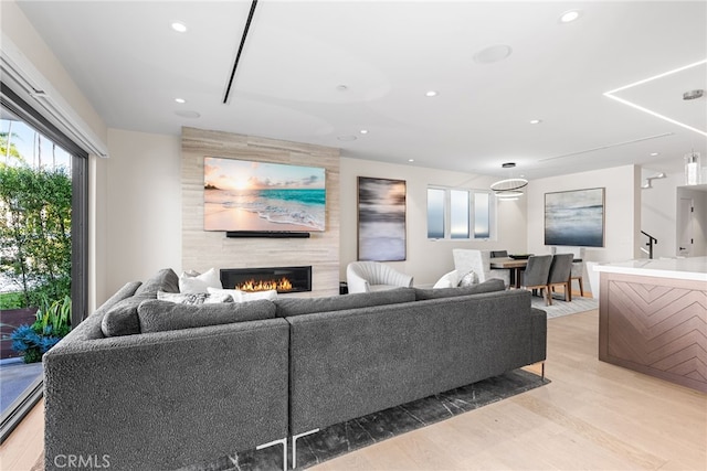 living room with a large fireplace and light hardwood / wood-style flooring