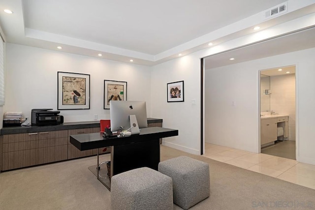 tiled office space featuring a tray ceiling