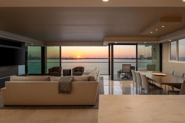 living room featuring a wall of windows and a water view