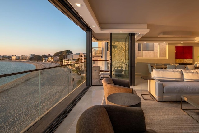 balcony at dusk with outdoor lounge area and a water view