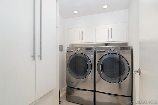 laundry area with cabinets and washer and clothes dryer