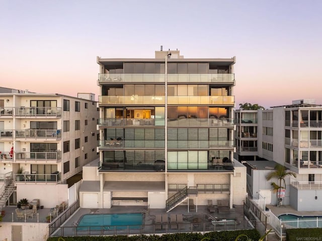 outdoor building at dusk featuring a community pool