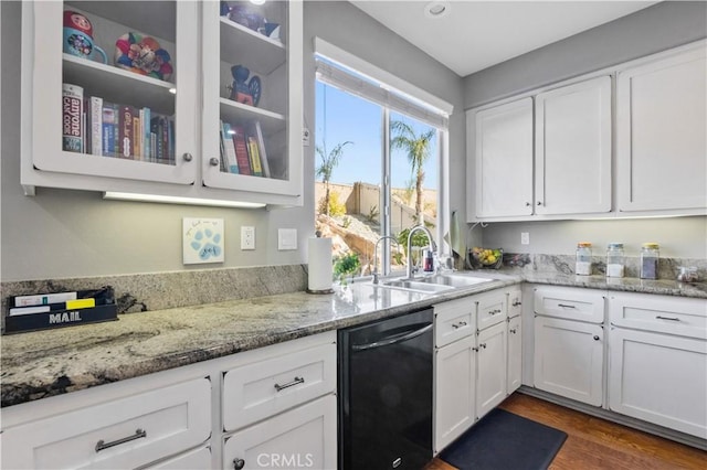 kitchen featuring dark wood-type flooring, sink, black dishwasher, light stone countertops, and white cabinets