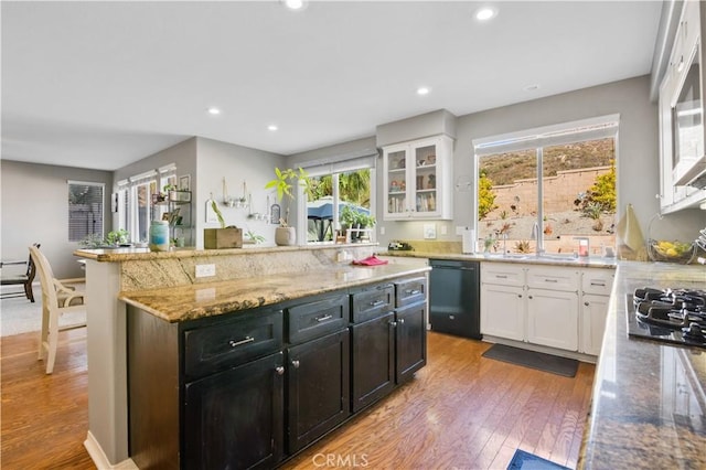 kitchen with dishwasher, sink, white cabinets, and light stone counters