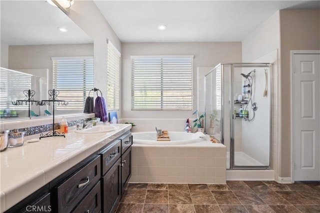 bathroom featuring vanity and shower with separate bathtub