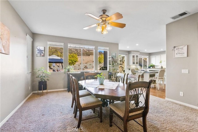 carpeted dining space featuring ceiling fan