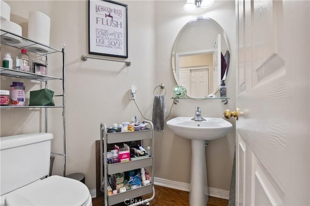 bathroom featuring wood-type flooring, sink, and toilet