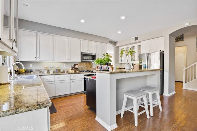 kitchen with sink, stainless steel appliances, white cabinets, and a kitchen island