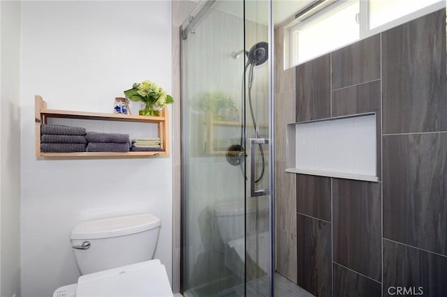 bathroom with toilet and an enclosed shower