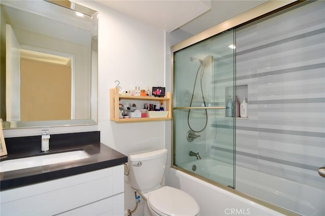 full bathroom with toilet, bath / shower combo with glass door, and vanity