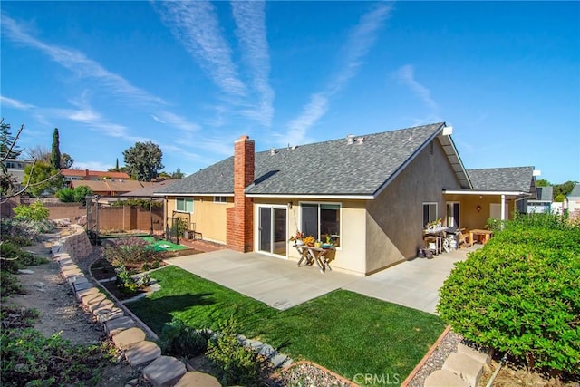 back of house featuring a lawn and a patio