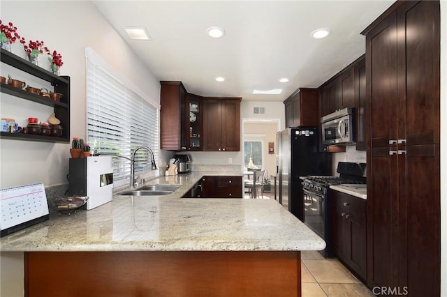 kitchen featuring light stone countertops, sink, kitchen peninsula, and stainless steel appliances