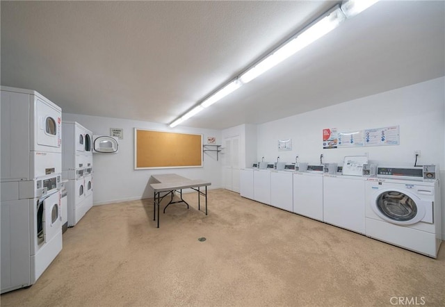 clothes washing area with stacked washing maching and dryer, light colored carpet, and washer and clothes dryer