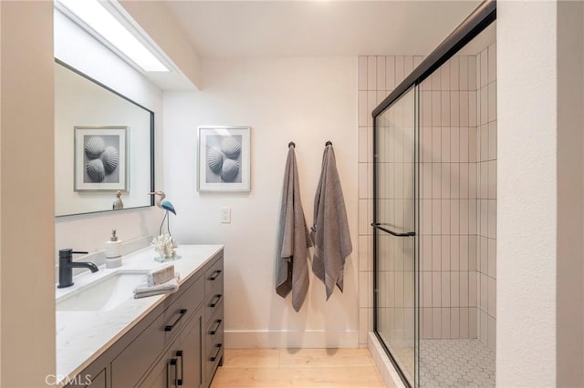 bathroom featuring a shower with shower door, vanity, and hardwood / wood-style floors