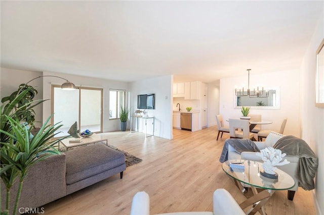 living room featuring a chandelier, light hardwood / wood-style flooring, and sink