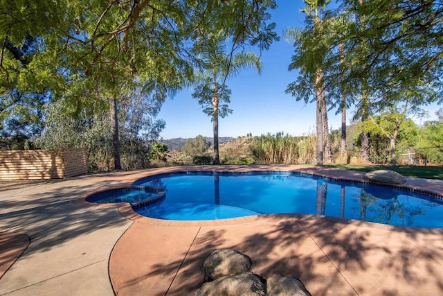 view of pool featuring a patio area and an in ground hot tub