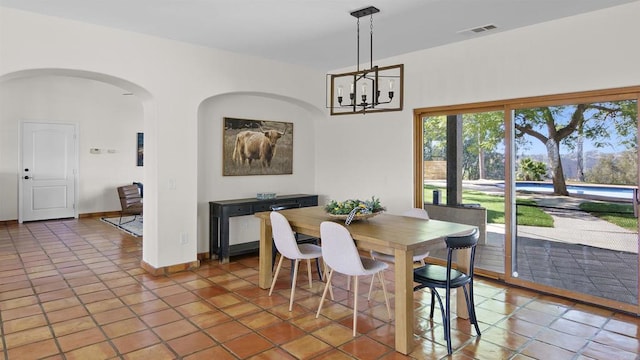 dining space with tile patterned floors and a chandelier