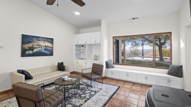 tiled living room with ceiling fan and high vaulted ceiling