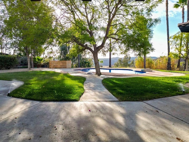 view of community featuring a pool and a lawn