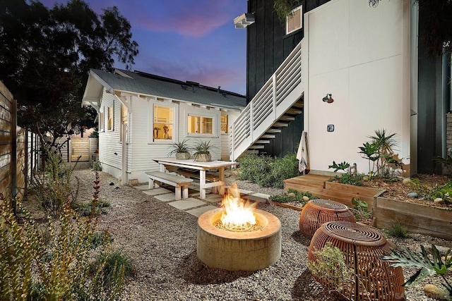 back house at dusk with an outdoor fire pit