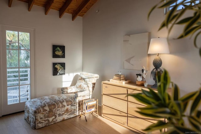 living area featuring wooden ceiling, a healthy amount of sunlight, wood-type flooring, and vaulted ceiling with beams