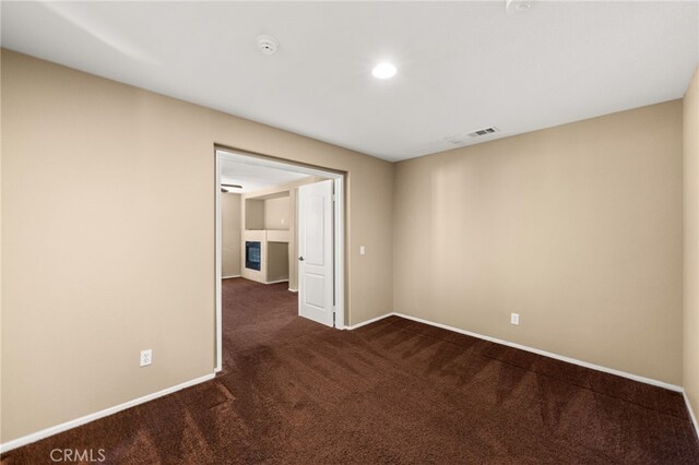 unfurnished room featuring dark carpet